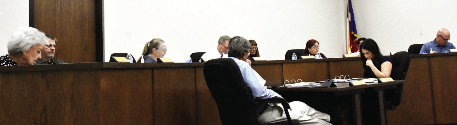 IT'S IN THE DETAILS--City commissioners examine a preliminary version of the proposed new city budget during a regular commission meeting July 6. In the foreground, City Attorney Audie Sciumbato and City Secretary Franchesca Jimenez pore over the details as well. (Photo by Jim Steiert)