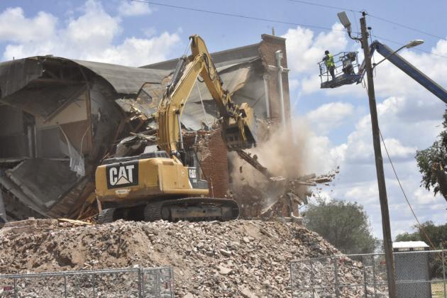 TOPPLING A RELIC--Heavy equipment brings down wood and brick and mortar, metal and windows of Stanton Junior High/Hereford High School of yesteryear, but can't erase the fond memories and lessons learned. (Photo by Jim Steiert)
