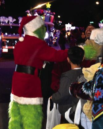 GRINCH WORKS THE CROWD—This Grinch was busy glad-handing it with youngsters during the lighted Christmas Parade.(Photo by Jim Steiert)