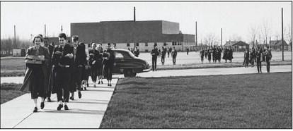 HIGH SCHOOL MIGRATION—This photo from December of 1954 shows Hereford students moving their things to the new digs of Hereford High School from what had previously been HHS and was to become Stanton Junior High. Note the classic car, and the apparel of the students, a scene right out of “Back to the Future.”