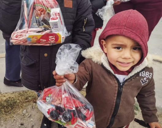 Boy in Juarez, Mexico receiving his Christmas bag.