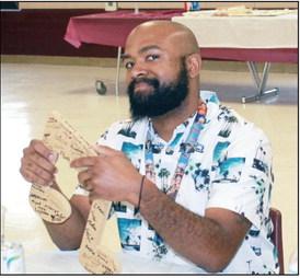 Mr. Malik Boyd with a musical note signed by the band members