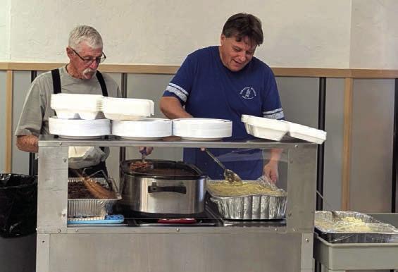 SERVING CHOW—Larry Carlson and Jim Layman serve up food at the Samaritan Hospice Dessert Auction and Brisket Dinner held November 25 at the Kings Manor Lamar Room.