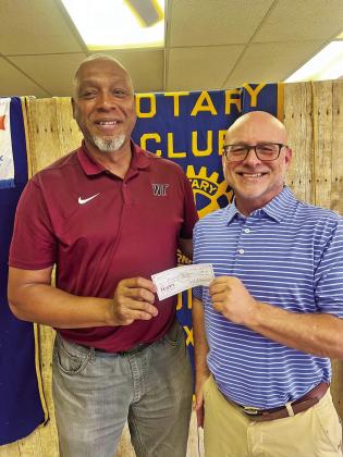Joseph’s Storehouse representative Tyson Willis accepted a donation from Robert Bazemore of Tulia Rotary Club.