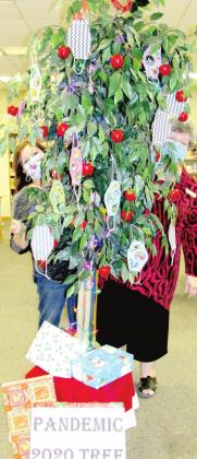 No, it's not Santa's helpers - it's librarians Sulema Oltivero (left) and Gaye Reily (right) peeking out from a Pandemic 2020 Tree.