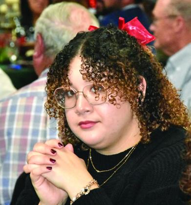 A CURLED BOW LOOK—Jasmine de la Cruz styles long curls and a red Christmas bow at the Festival of Trees Gala. (Photo by Jim Steiert)