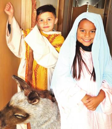 Traveling of Census — Crew Clark, left, and Jaselyn Gonzalez take on the attire of Joseph and Mary and pose with a prop donkey as they anticipate the upcoming “Walk Through Bethlehem” and a celebration of Las Posadas on Sunday, Dec. 5 at Saint Anthony School in Hereford.