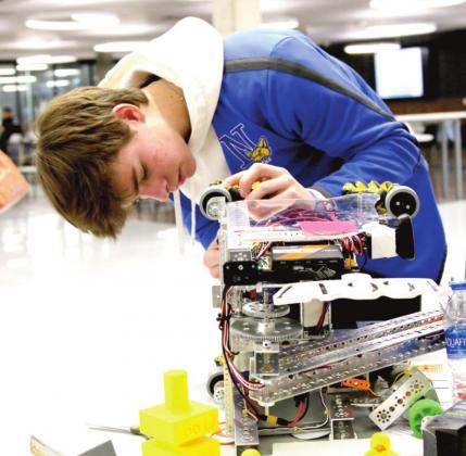 Naz Robotics team 16617 member Luke Schulte makes adjustments to the robot. (photo by Chloe Birkenfeld)