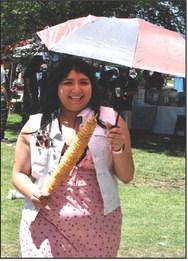 PARASOL AND PAPAS--Wielding a parasol against the heat of the sun, this Jamaica patron chose spiral potatoes as a treat.