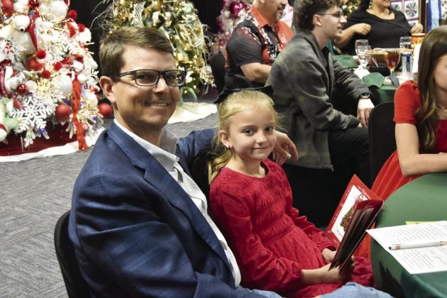 OUT WITH DAD—Just a nice evening out, shopping the tree list at the Festival of Trees. (Photo by Jim Steiert)
