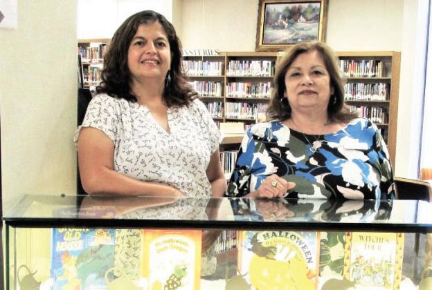 Library display for October 2024 showcases library staff Sulema Oltivero and Patty Padilla and a space for Simon Skeleton to read Halloween stories