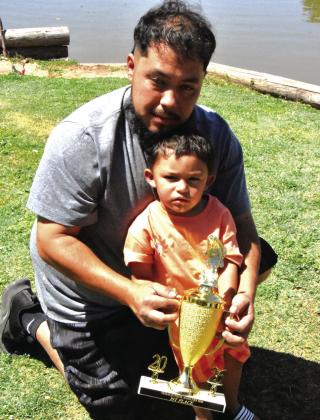 A LITTLE HELP FROM DAD—Jai Gonzalez, 3, shows off a pair of nice channel catfish caught at the Texas Junior angler event Saturday, May 16 at Josserand Aquatic Park Pond, with a steady hand from Dad, Jaden, on the stringer. (Photo by Jim Steiert)