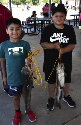 PISCATORIAL PALS—Aziel Sifuentes, 6, and Leo Gallardo, 9, show off hefty catfish reeled in at the Texas Junior angler event Saturday, May 16 at Josserand Aquatic Park Pond. Hereford’s Texas Junior Angler festivities, held twice yearly, are the longest running in Texas. (Photo by Jim Steiert)