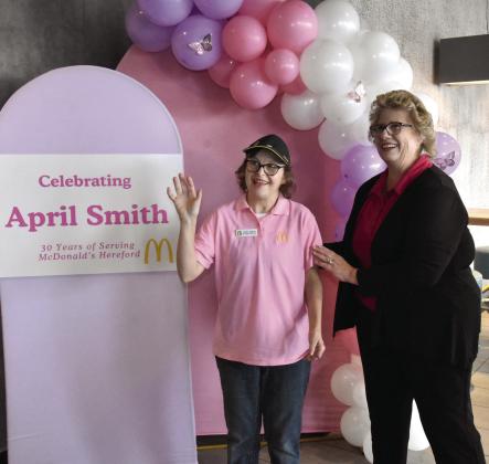 HI THERE--April Smith performs one of her favorite functions as an employee of McDonald's, greeting guests, while Owner/Manager Susan Credle helps her enjoy the moment. (Photo by Jim Steiert)