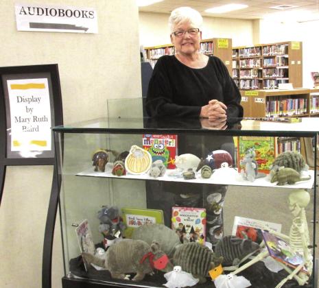 Mary Ruth Baird is shown with her collection of stuffed armadillos, who are masked and ready for Halloween at Rhoads Memorial Library. The October display of the month also features Stuart Skeleton reading spine-tingling tales to them and visiting ghosts.