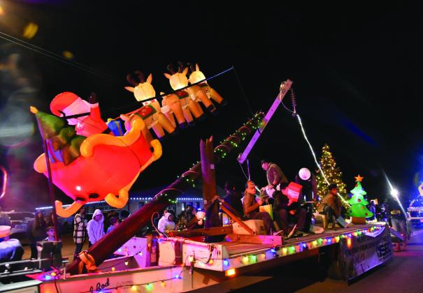 POWER LINE FLYOVER—Santa and his reindeer make a low pass warning all to be safe around downed power lines in this Deaf Smith Electric Cooperative float that won Best Lighted in the Lighted Christmas Parade December 8. The Cooperative had multiple lighted vehicles in the parade. (Photo by Jim Steiert)