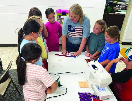 To get ready for the nation's 250th birthday, Castro Coun - ty 4-H made American Flag T-shirts and coasters June 14. The group learned about using fusible to make our flag, sewing on a T-shirt and using a sewing machine to not stitch both sides, strip piecing to make a coaster and us - ing fusible to add stars. (Courtesy photos)
