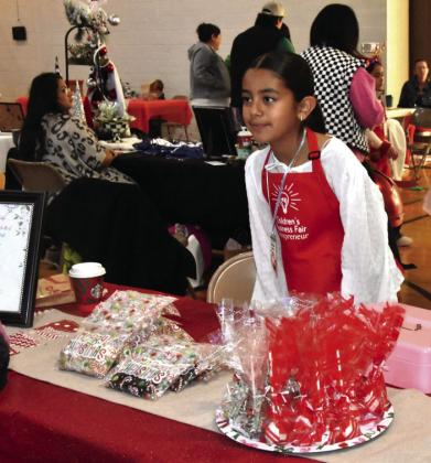 GETTIN’ SPICY— Brennan, 12, and Anson Yosten, 11, offered packages of their own secret blend of spices. (Photos by Jim Steiert) BAKED BONANZA—Kenzilina Olmos was all business offering an array of baked creations.