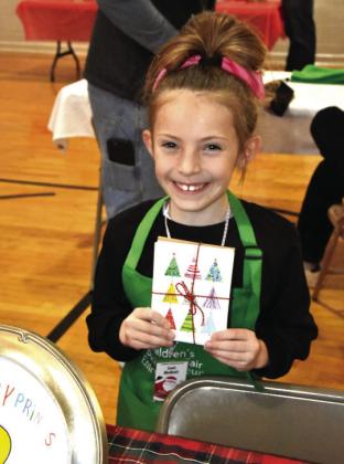 PICK A CARD—Lexi McNutt, 7, offered your choice of her own self-created Christmas or other occasion cards at her Happy Prints booth.