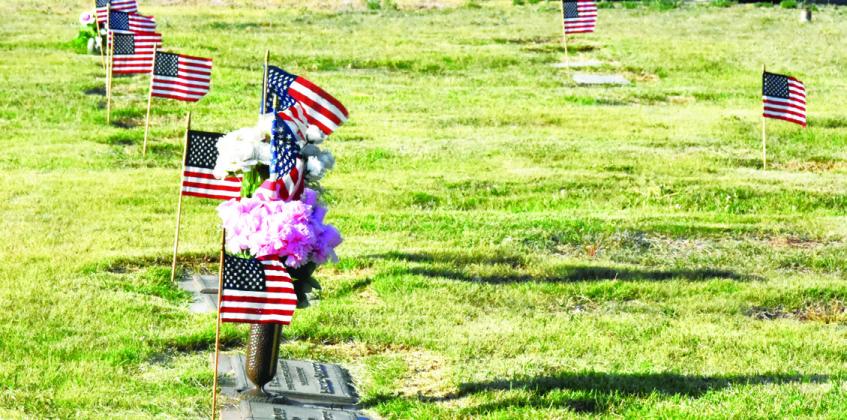 SILENT TRIBUTE--Flags fluttering in local cemeteries this weekend mark a show of respect for those who gave a last full measure of devotion for their country. Take a moment to walk among them and remember. (Photo by Jim Steiert)
