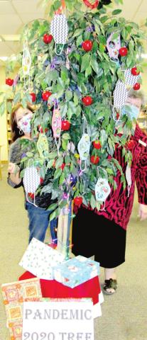 No, it's not Santa's helpers - it's librarians Sulema Oltivero (left) and Gaye Reily (right) peeking out from a Pandemic 2020 Tree.