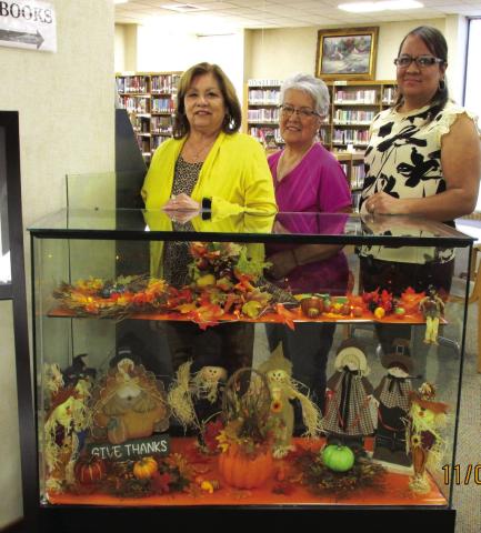 A Thanksgiving-themed exhibit serves as the November display at Rhoads Memorial Library, courtesy of Gloria Hernandez of Castro County Cares. She is flanked by library personnel who staged the display: Sulema Oltivero, left, and Rosa Medina, right, who is the library's newest staff member.