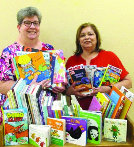 New books, courtesy of a $1,000 grant awarded recently to Rhoads Memorial Library, are displayed by Gaye Reily, left, and Sulema Oltivero of the local library. The 72 books are for ages pre-K through fifth grade. The grant was provided by Texas Panhandle Library Reading Initiative for Young Children.