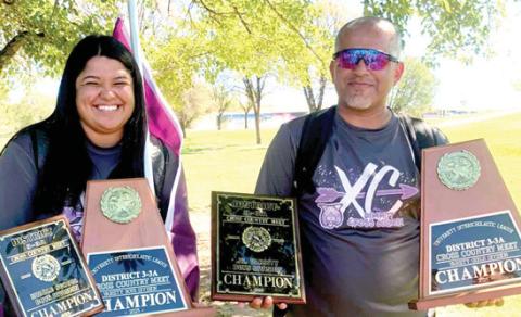 With big team wins at the district cross country meet, DHS/ DMS assistant coach Haley Bonila and head coach Jason Ayala show off the first-place plaques earned by theDHS varsity girls and boys, DHS JV boys, and DMS boys.