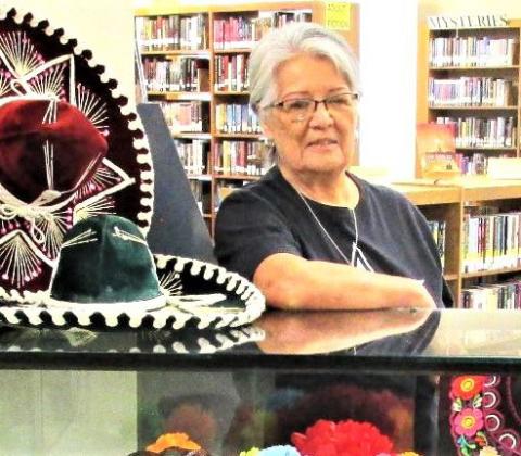 September’s Display of the Month at Rhoads Memorial Library, shown with Gloria Hernandez, features items pertaining to Hispanic heritage.
