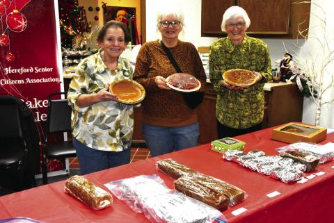 BAKE SALE STALWARTS--The baked goods and home made candy sale at the Festival of Trees is a sure draw every years. Chances are, if you have browsed and patronized the sale, you have encountered this trio of ladies who handle display, sale, and baking duties. From left are Terry Rhyne, Carla Rampley, and Irma Murphey styling pies. (Photo by Jim Steiert)
