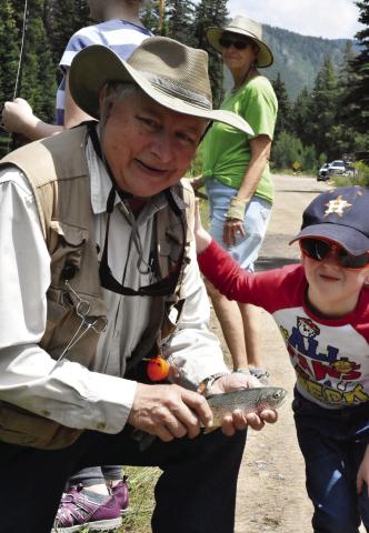 WHAT THEY BITIN' ON? Just a couple of fishing buddies, adapting to what the fish are taking. A grandson catches his first rainbow trout on the same fly rod his granddad acquired at the age of 14. (Debbie Mc-Glothlin photo)