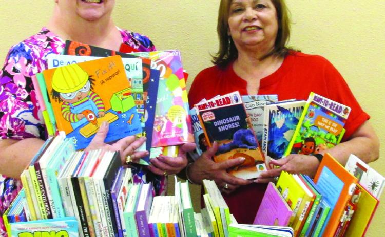 New books, courtesy of a $1,000 grant awarded recently to Rhoads Memorial Library, are displayed by Gaye Reily, left, and Sulema Oltivero of the local library. The 72 books are for ages pre-K through fifth grade. The grant was provided by Texas Panhandle Library Reading Initiative for Young Children.