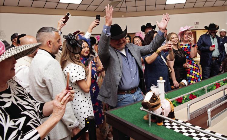 WE WIN THE DERBY!-- Robert de la Cruz of First Financial Bank celebrates power pony Lady Penny crossing the finish line first in the seventh annual running of the electronic eohippus Kentucky Derby at the Hereford Senior Citizens Center Gala May 2. (Photo Courtesy of Pam McNutt)