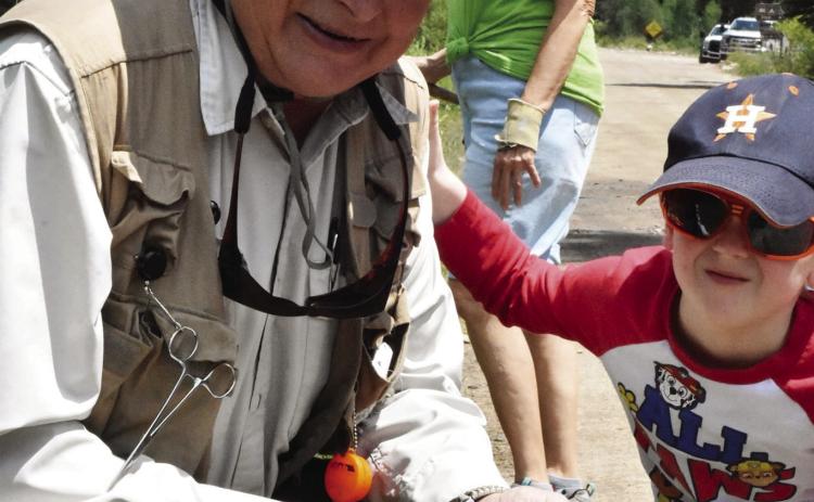 WHAT THEY BITIN' ON? Just a couple of fishing buddies, adapting to what the fish are taking. A grandson catches his first rainbow trout on the same fly rod his granddad acquired at the age of 14. (Debbie Mc-Glothlin photo)